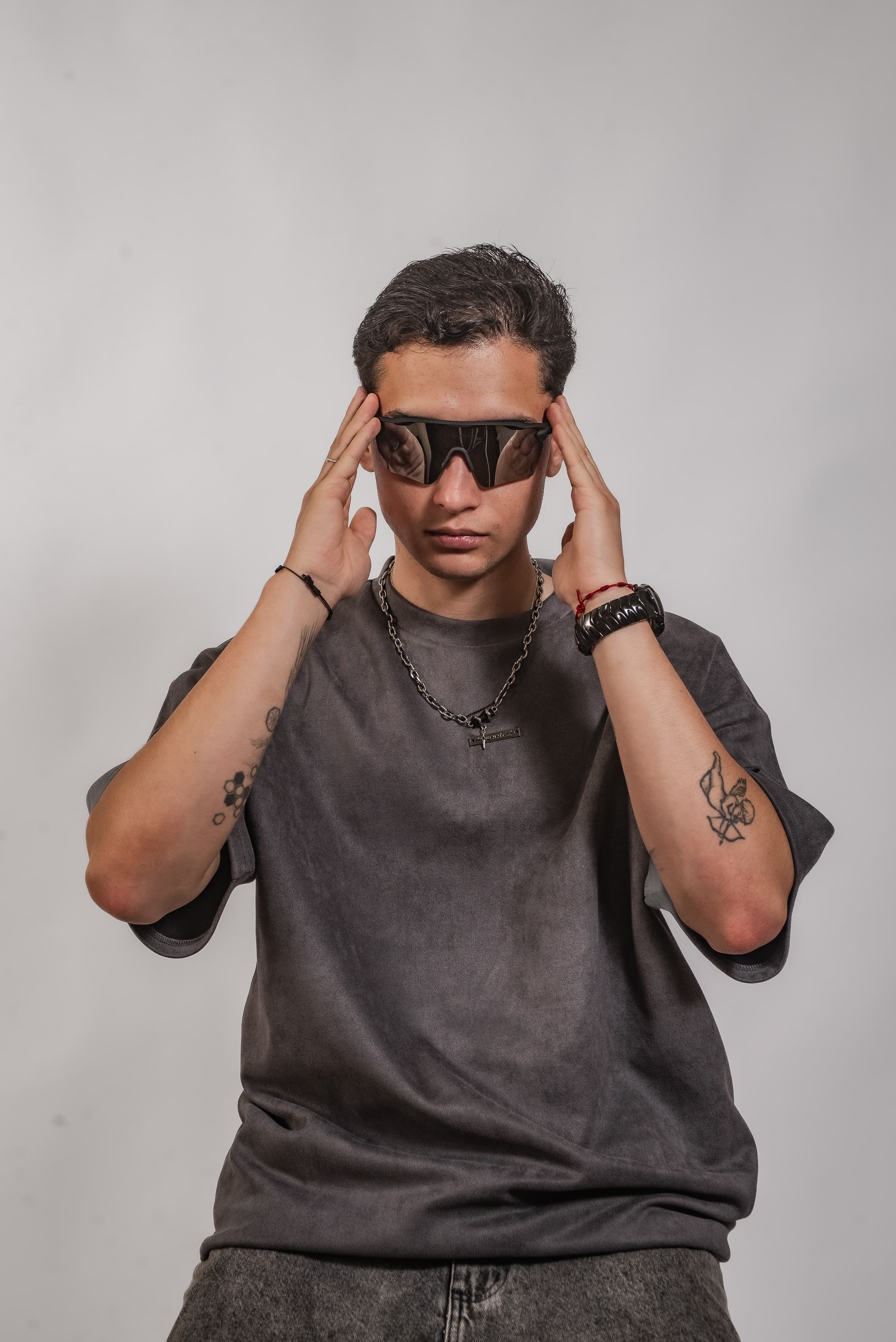 Retrato profissional do DJ Rubens ajustando os óculos em estúdio